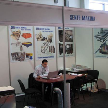 SENTE Makina fuar standı, makineler ve ekipmanlar sergilendi, bir çalışan dizüstü bilgisayar kullanıyor.